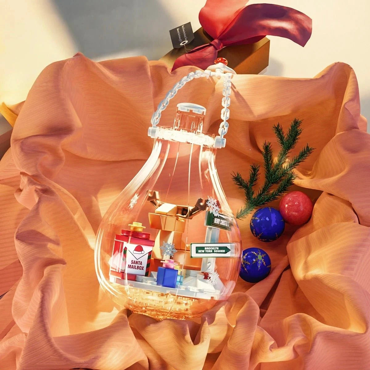 Boule de Noël lumineuse féerique posée sur tissu rose avec cadeaux
