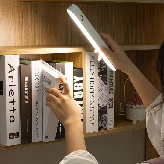 Lampe LED magnétique Luminate tenue en main bibliothèque livres design blanc — Mon Univers - Mes Lumières