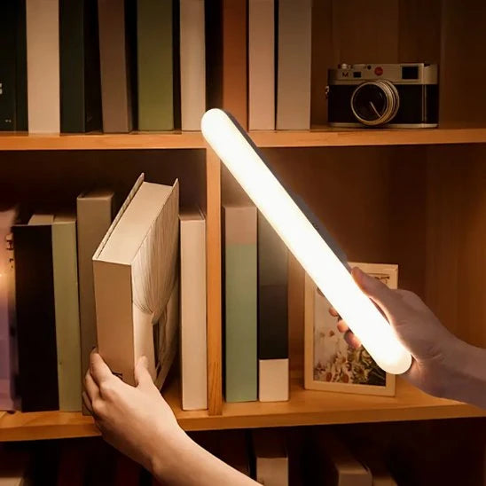 Lampe LED magnétique Luminate tenue en main bibliothèque livres lumière chaude — Mon Univers - Mes Lumières
