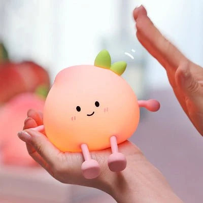 Veilleuse LumiBuddy Pêche lumière orange chaude tenue dans la main — Mon Univers - Mes Lumières